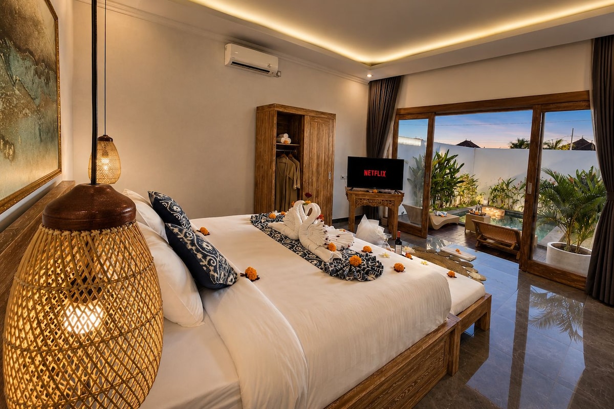 Habitación de hotel con una cama grande, televisión, un armario de madera y vistas al exterior.