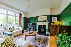 Ein Wohnzimmer mit Kamin, Fernseher und einer Couch.