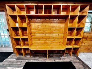 Un banco de madera con varias estanterías en una habitación con suelo de espiga.