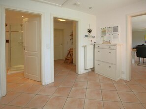 Een kamer met een douche, een radiator en een kast met lades.