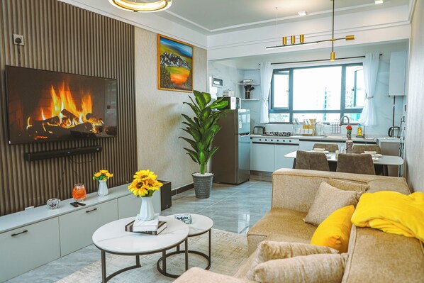 Ein modernes Wohnzimmer mit Kamin, Essbereich und Küche.