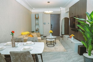 A modern living room with a dining area, a sofa set, a coffee table, and a large potted plant. - Cozy 1-bedroom apartment with gym, swimming pool in fabulous Nairobi Lavington (Nairobi)