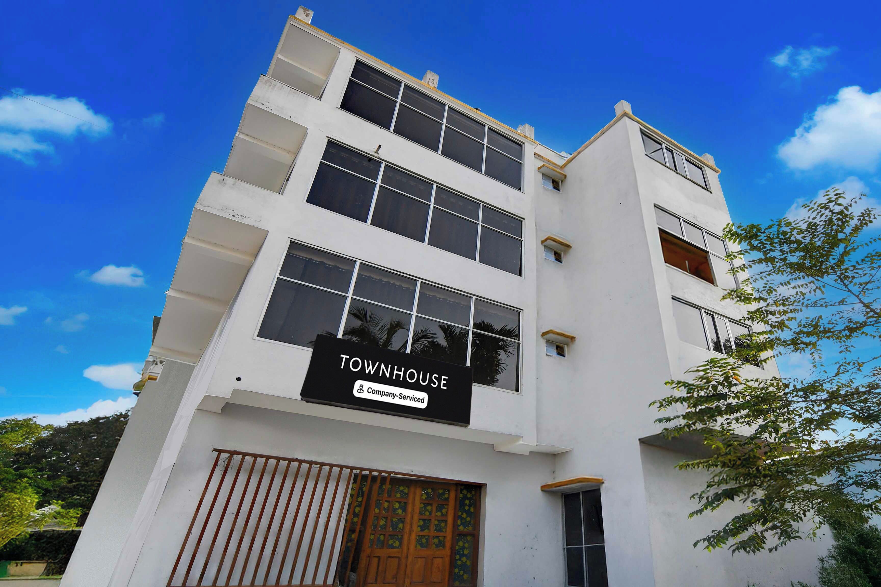 Un edificio de varios pisos con un letrero que indica que es una casa adosada con servicios de empresa.