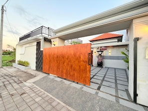 A residential property with a gated entrance, a balcony, and a tiled patio area. - Villa Romansa Lovina (Buleleng)