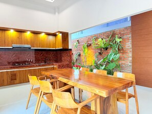 Una cocina moderna con armarios de madera, salpicadero de mármol y pared decorativa de ladrillo.