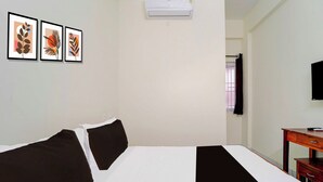 A hotel room with a bed, a desk, a television, and three framed artworks on the wall. - Townhouse Coimbatore Peelamedu (Coimbatore)