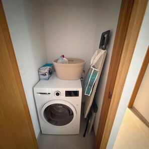 A compact laundry room with a washing machine, a drying rack, and a small storage area. - Villa Daya - private pool - ocean view - 8 guests - 4 bedrooms - 3 bathrooms (Salobrena)