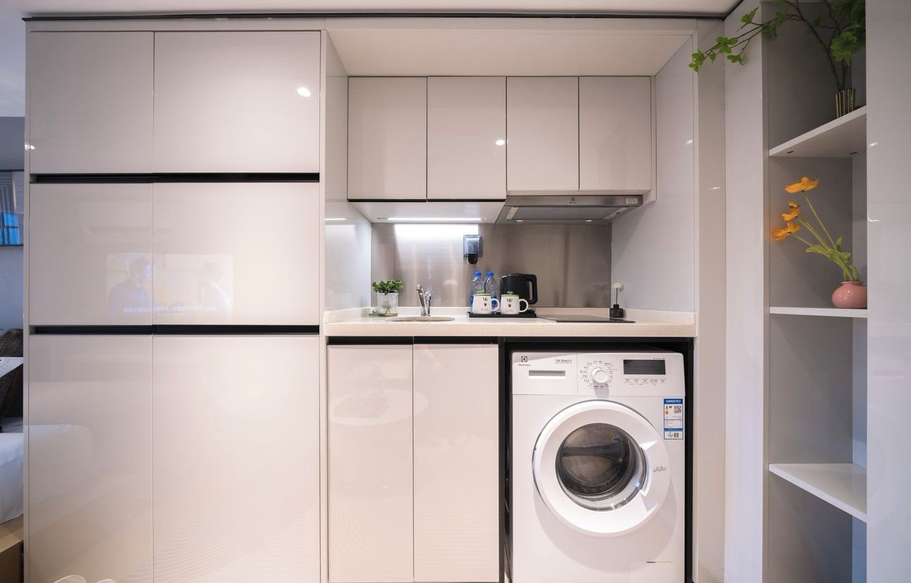 A compact kitchen with a built-in washer and dryer, a microwave, and a small countertop area.
