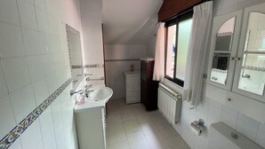Ein Badezimmer mit Waschbecken, Spiegel und einem fenster mit Vorhängen.