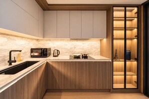 A modern kitchen with a built-in microwave, kettle, and stove. - The Nelson Luxury 3BR Apartment in Lang Ha street – Free Pool, Gym & Sauna (Hà Nội)