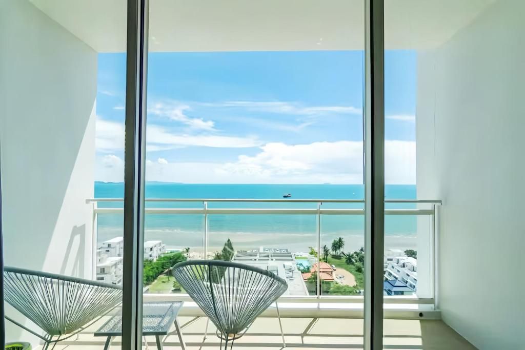 Een balkon met uitzicht op zee en gebouwen.