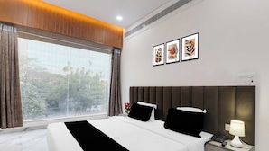 A hotel room with a large bed, a nightstand, a lamp, and three framed pictures on the wall. - Townhouse Lucknow Emerald Mall (Lucknow)