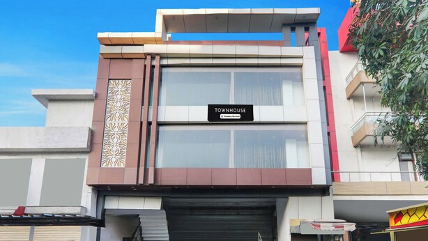 A modern building with a sign reading 'TOWNHOUSE Company Serviced'. - Townhouse Lucknow Emerald Mall (Lucknow)