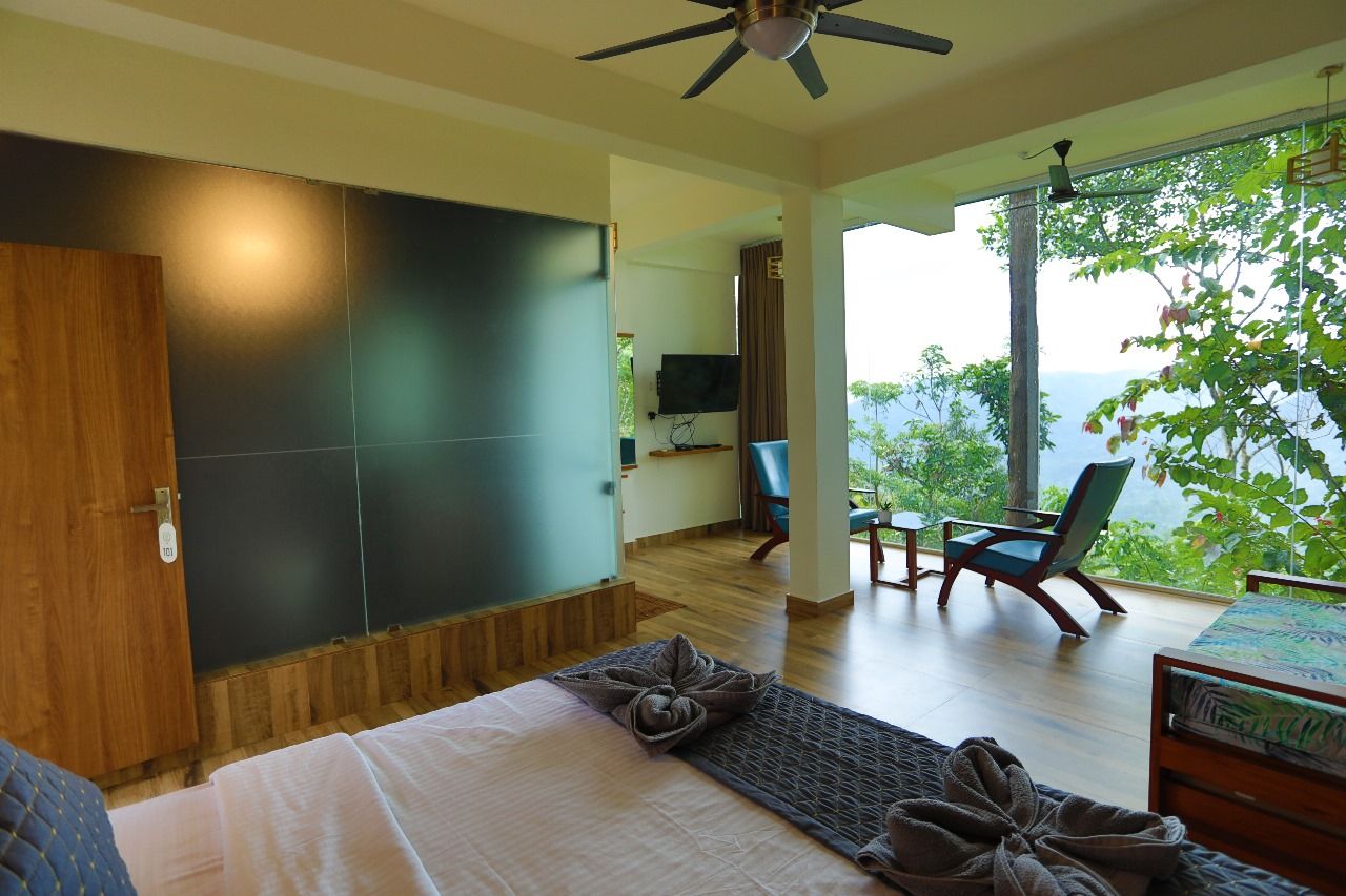 A bedroom with a bed, a ceiling fan, a TV, and a view of the outdoors.