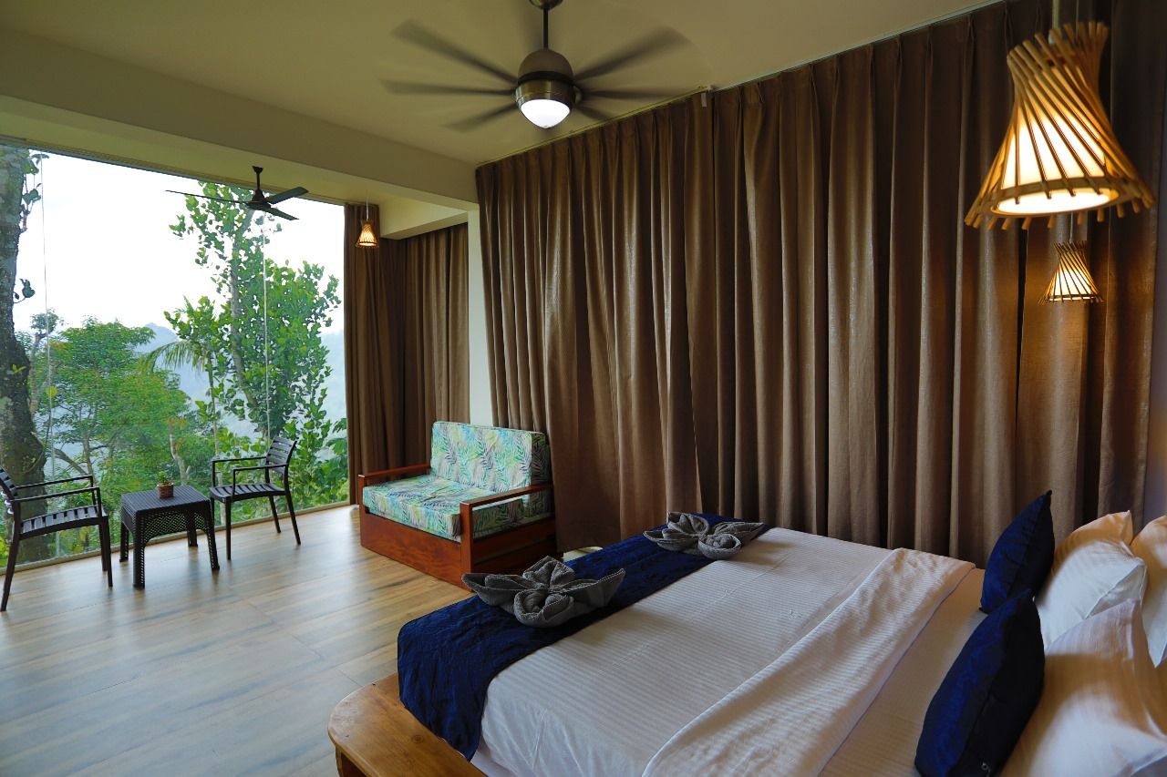Habitación de hotel con cama, una silla, una mesa y vistas al exterior.