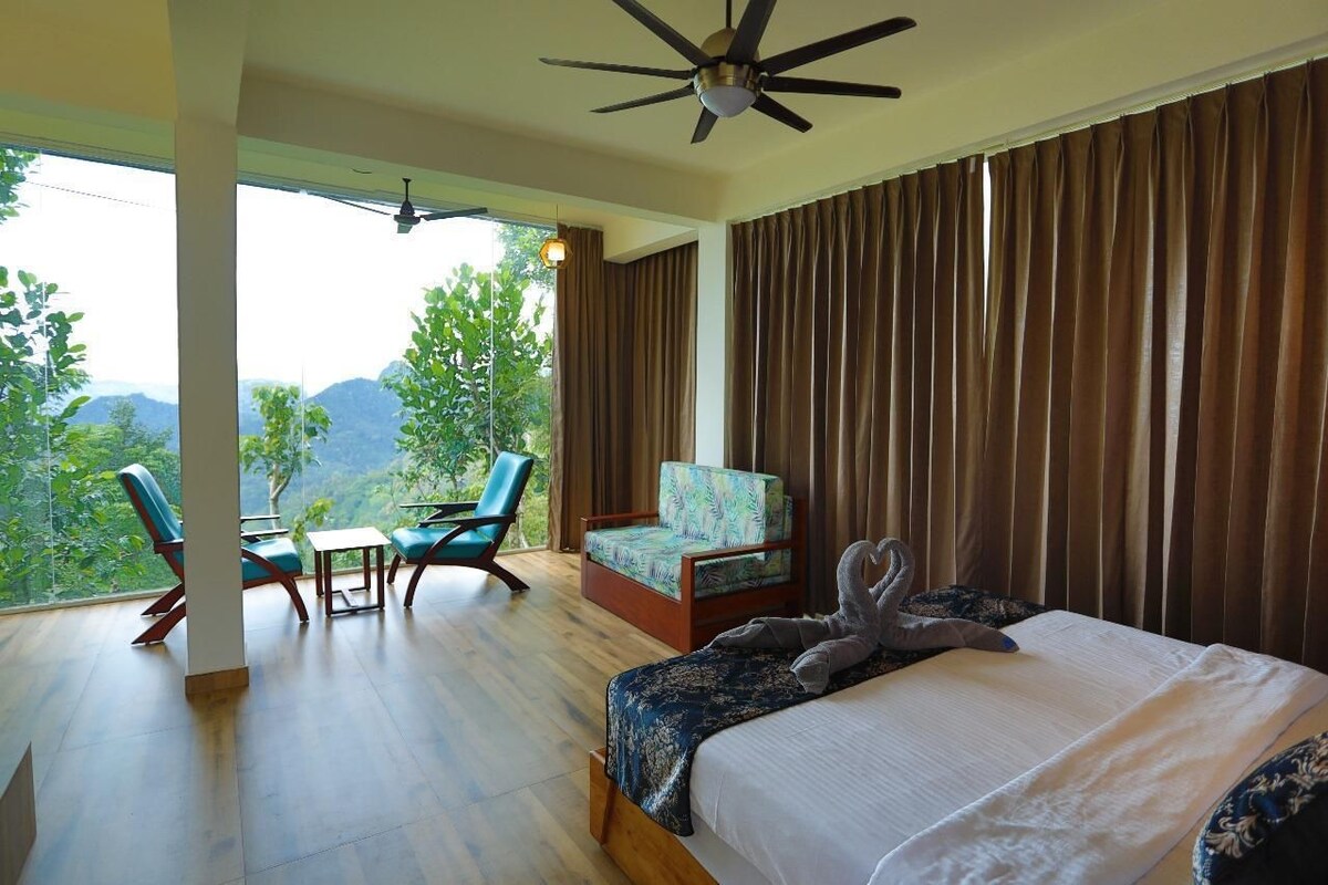 Un dormitorio con cama, una silla, una mesa y vistas al exterior.