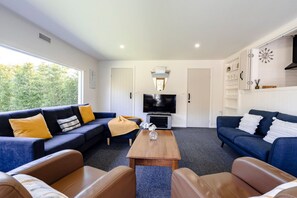 A modern living room with a sofa set, a coffee table, and a television.