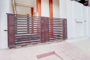 A gated entrance with a metal gate and a white wall. - Townhouse Faizabad Road Opp BBD (Lucknow)