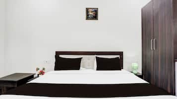 Ein Schlafzimmer mit Bett, Nachttisch, Lampe und Kleiderschrank.