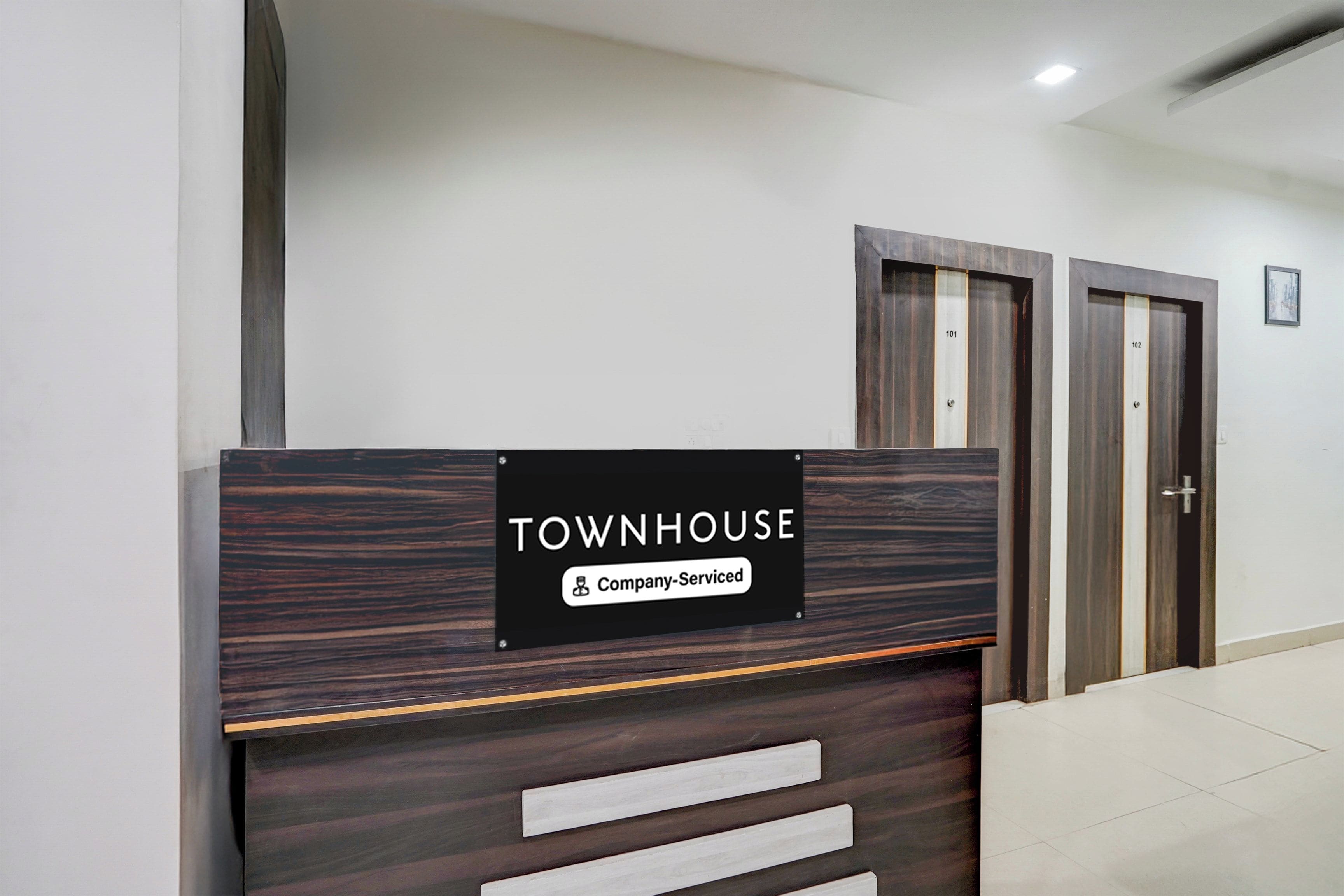 A reception desk with a sign indicating 'TOWNHOUSE' and 'Company-Serviced.'