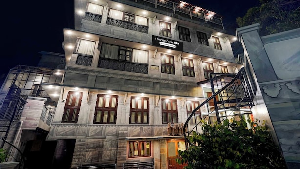 A multi-story building with a sign indicating it is a company-serviced townhouse. - Townhouse Oak Varanasi Ganga Ghat (Varanasi)