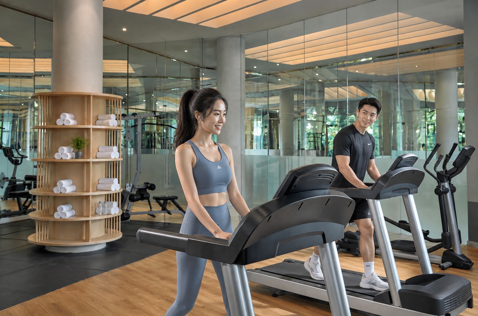 A gym with treadmills, a wooden display of towels, and exercise equipment.