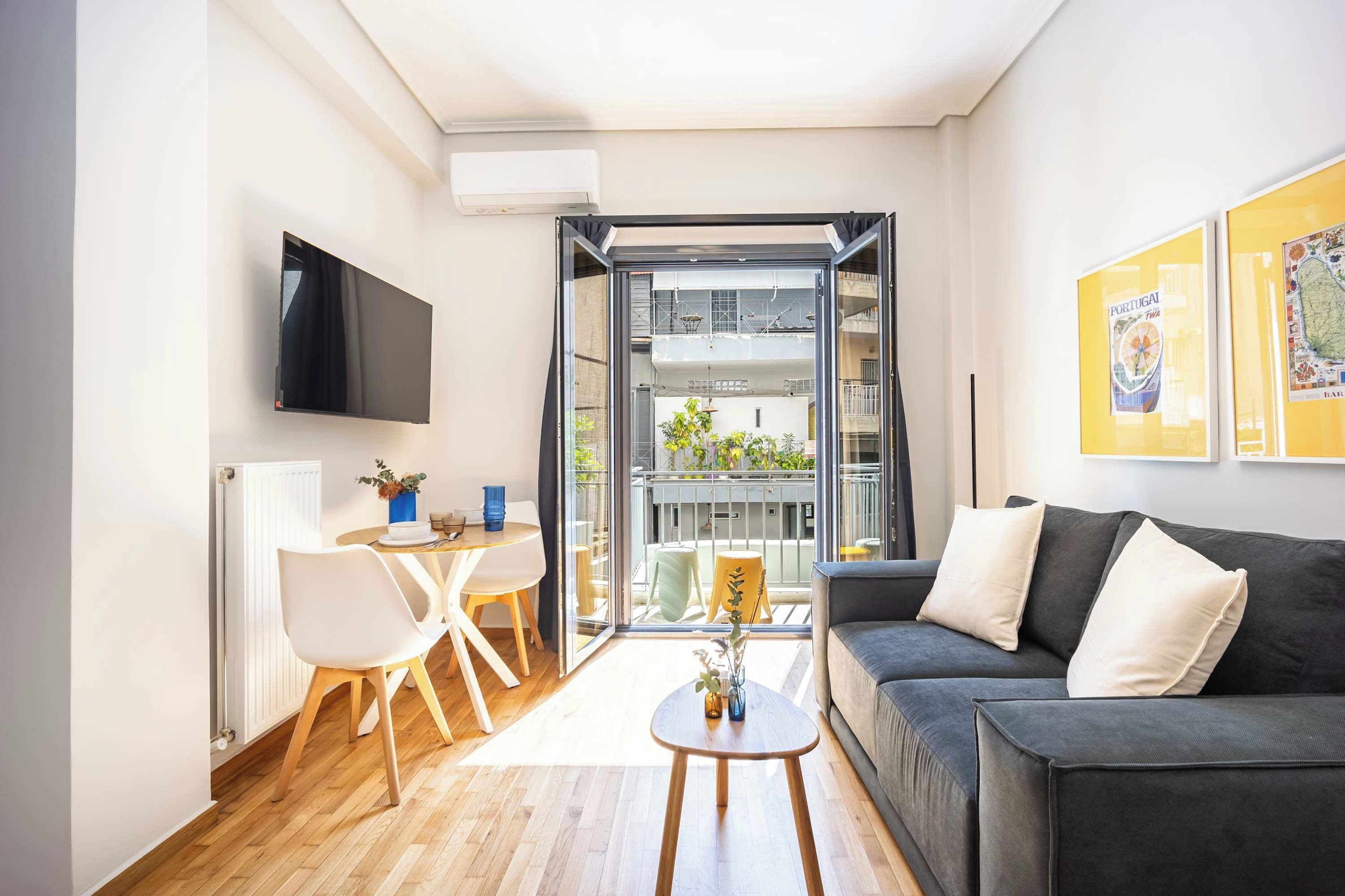Un salon moderne avec un canapé, une table basse et un téléviseur fixé au mur.