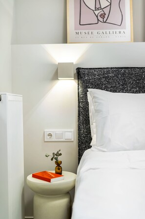 Ein Schlafzimmer mit einem Bett, einem Nachttisch und einer Wandleuchte.