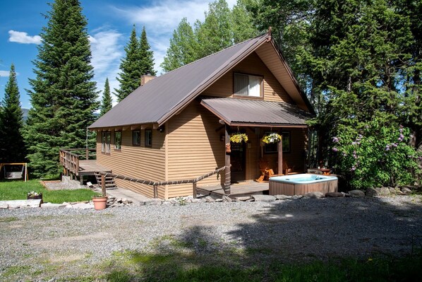 A wooden cabin with a hot tub, surrounded by trees and a deck. - Secluded Island Park Cabin with Hot Tub Near Yellowstone & Henrys Lake, Idaho (Island Park)