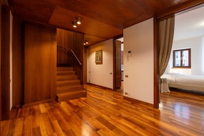 A spacious room with a wooden staircase, a bed, and a view of the outside. - Residenza Adua - 150 meters from the Verona Arena (Verona)