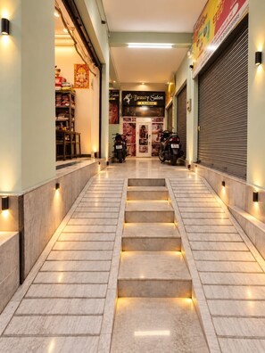A corridor with a staircase leading to a salon. - Geeta Bhawan Cozy Homestay (Varanasi)