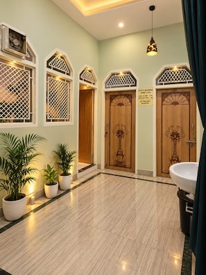 A hotel lobby with a check-in desk, potted plants, and a reception area. - Geeta Bhawan Cozy Homestay (Varanasi)
