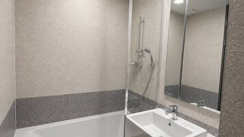 Un baño moderno con bañera, lavamanos y ducha.
