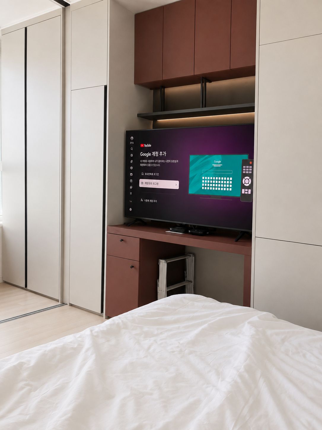A bedroom with a bed, a TV on a stand, and a wardrobe.
