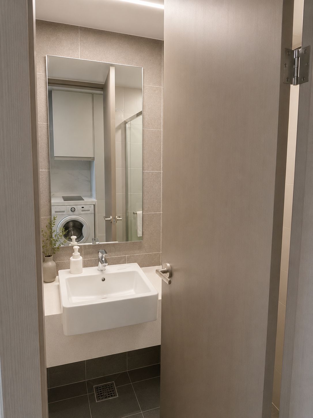 Un baño moderno con un lavamanos blanco, un espejo y una lavadora integrada.