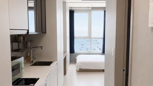 Una cocina moderna con lavadora, una cama y vistas al mar.