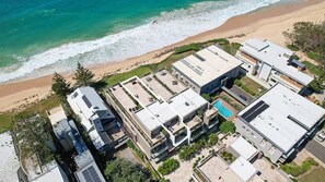 A residential area with modern buildings, a swimming pool, and a beach. - Paradise Penthouse Ocean Views (The Entrance North)