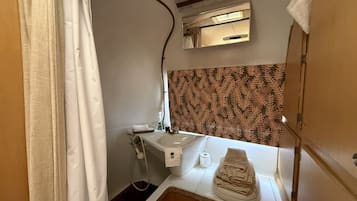 Une petite salle de bain comprenant une douche, un lavabo et des toilettes.