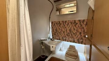 Une petite salle de bain comprenant une douche, un lavabo et des toilettes.