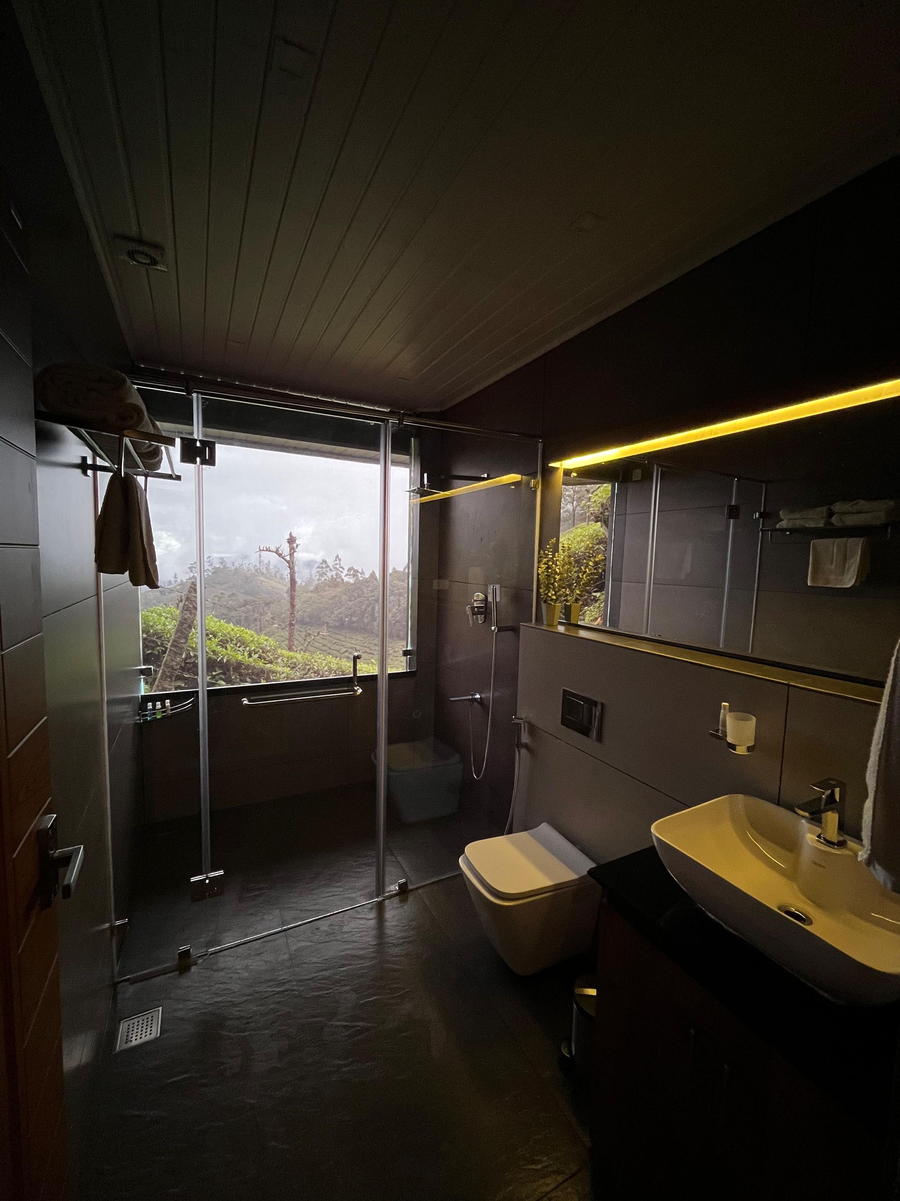 Ein modernes Badezimmer mit einer Duschkabine aus Glas, einer Toilette und einem Waschbecken.