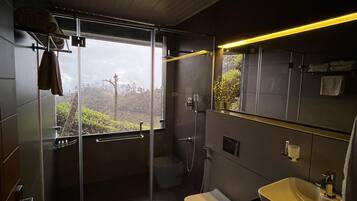 Ein modernes Badezimmer mit einer Duschkabine aus Glas, einer Toilette und einem Waschbecken.