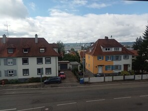 Una calle residencial con casas, cielo despejado y una vista distante de un paisaje urbano.