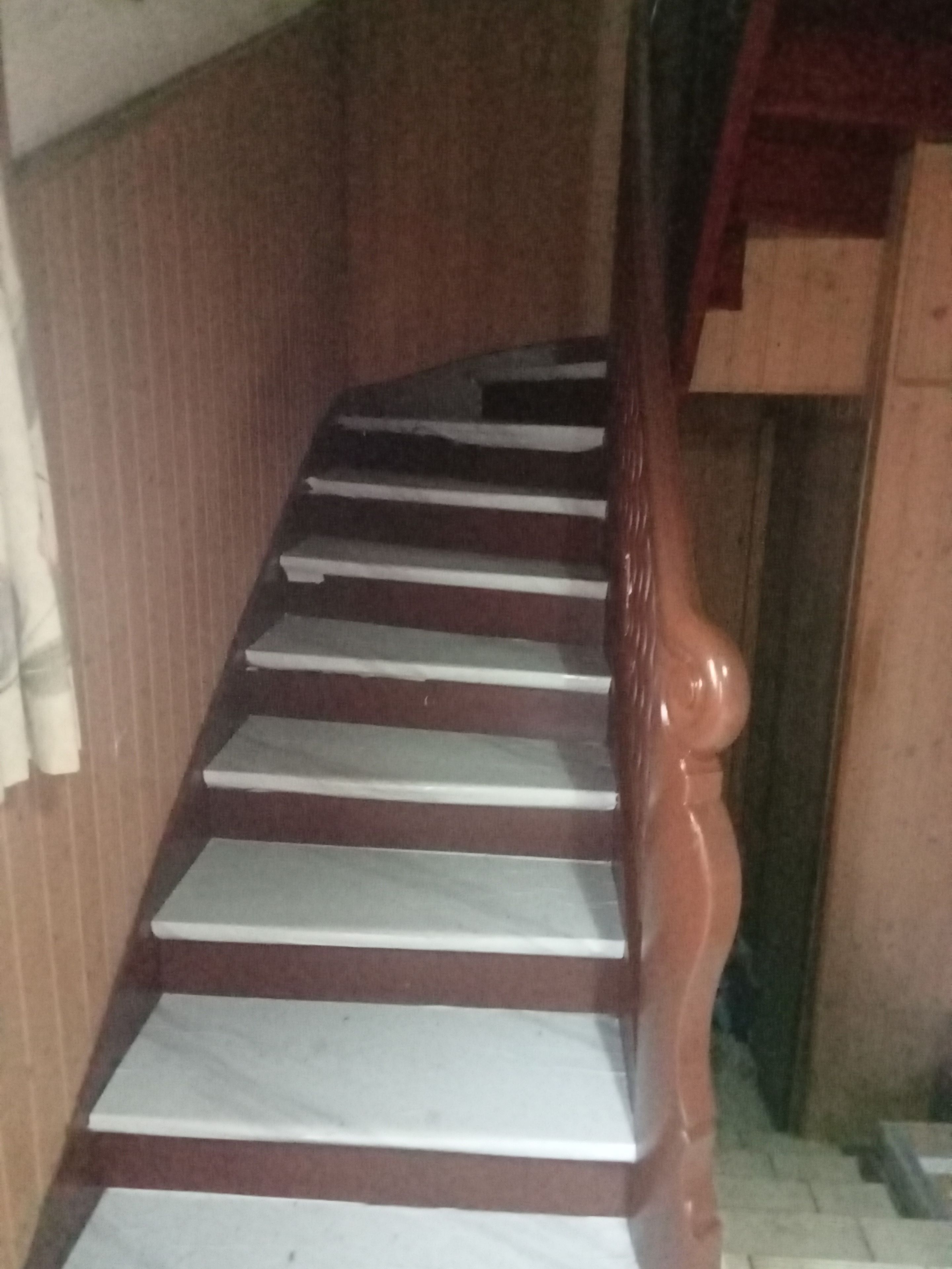 A staircase with wooden handrails and white steps.
