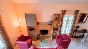 Ein Wohnzimmer mit einer Sofagarnitur, einem Fernseher und einem Kamin.