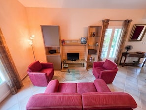 A living room with a sofa set, a TV, and a fireplace. - Villa Terrasse Olmeta-di-tuda Proche St Florent (Olmeta-di-Tuda)