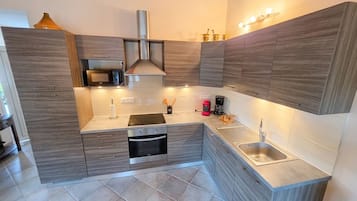 A modern kitchen with built-in appliances, a microwave, a stove, and a sink.