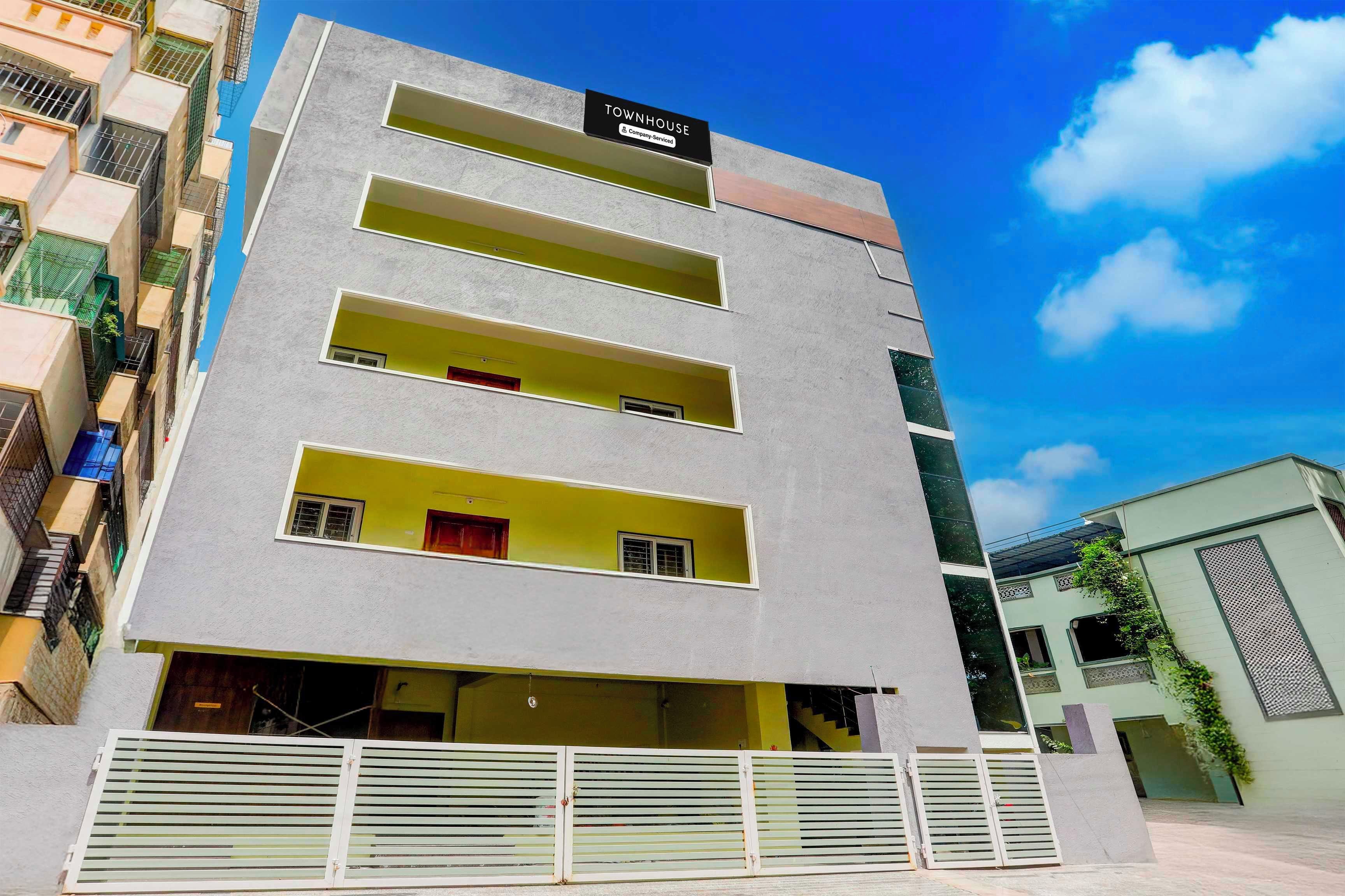 Un edificio de varios pisos con un cartel que indica que se trata de una casa adosada con servicios de empresa.
