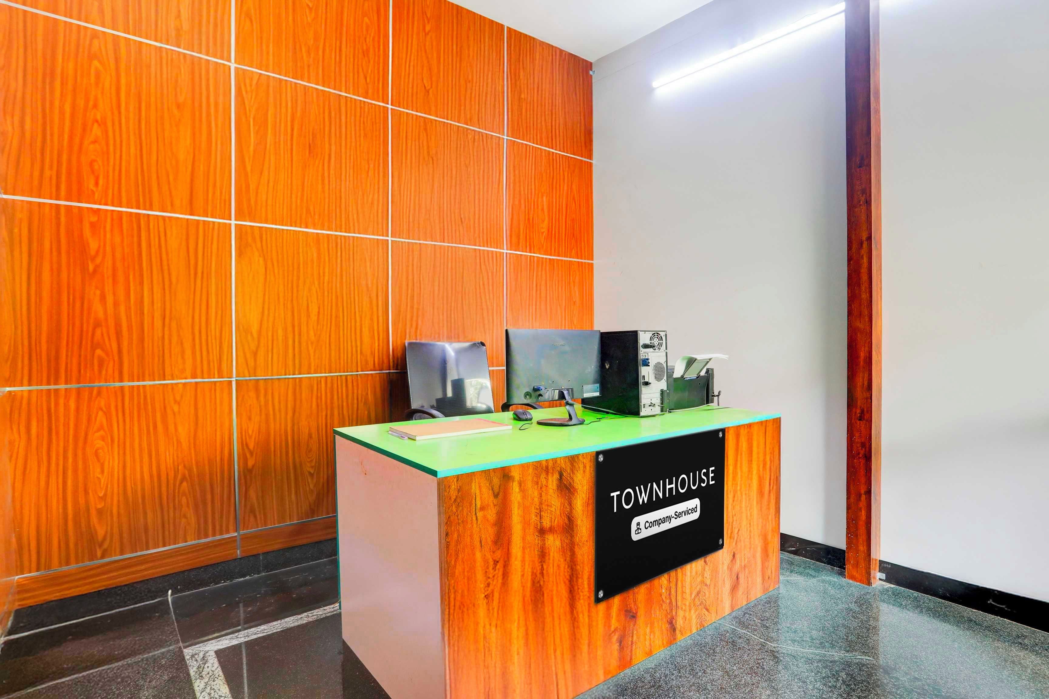 Una mesa de recepción con un cartel que dice 'TOWNHOUSE Company Serviced'.