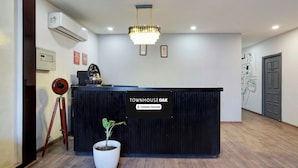 Una recepción con un letrero que indica 'TOWNHOUSE OAK' y 'Servicio de empresa'.