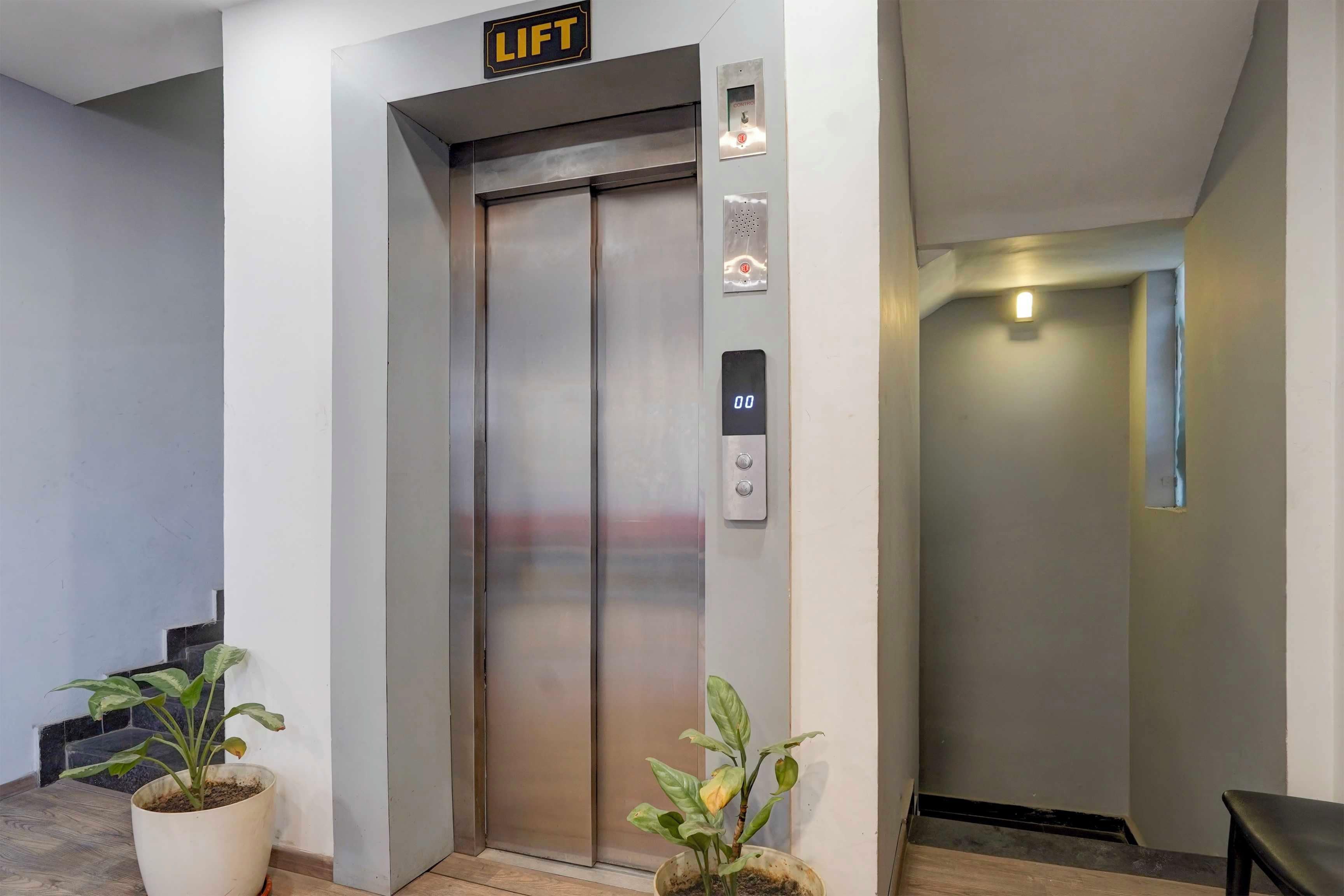 An elevator with a control panel, a digital display, and a 'LIFT' sign above it.